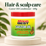 A white plastic jar of Africa's Best Castor Oil Hair & Scalp Conditioner with a red lid, displayed on a round beige pedestal with a soft-focus background of green leaves.