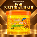 A jar of Ampro Pro Styl Argan Oil Gel with an orange lid and golden-yellow gel inside, set against a luxurious gold and black background with the text 'FOR NATURAL HAIR'.