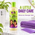 A bottle of Kids Originals Shea Butter Moisturising Hair Lotion stands on a marble bathroom counter with a purple towel, purple comb, soap dispenser, and plant in the background. Text on the right reads 'A LITTLE DAILY CARE'.