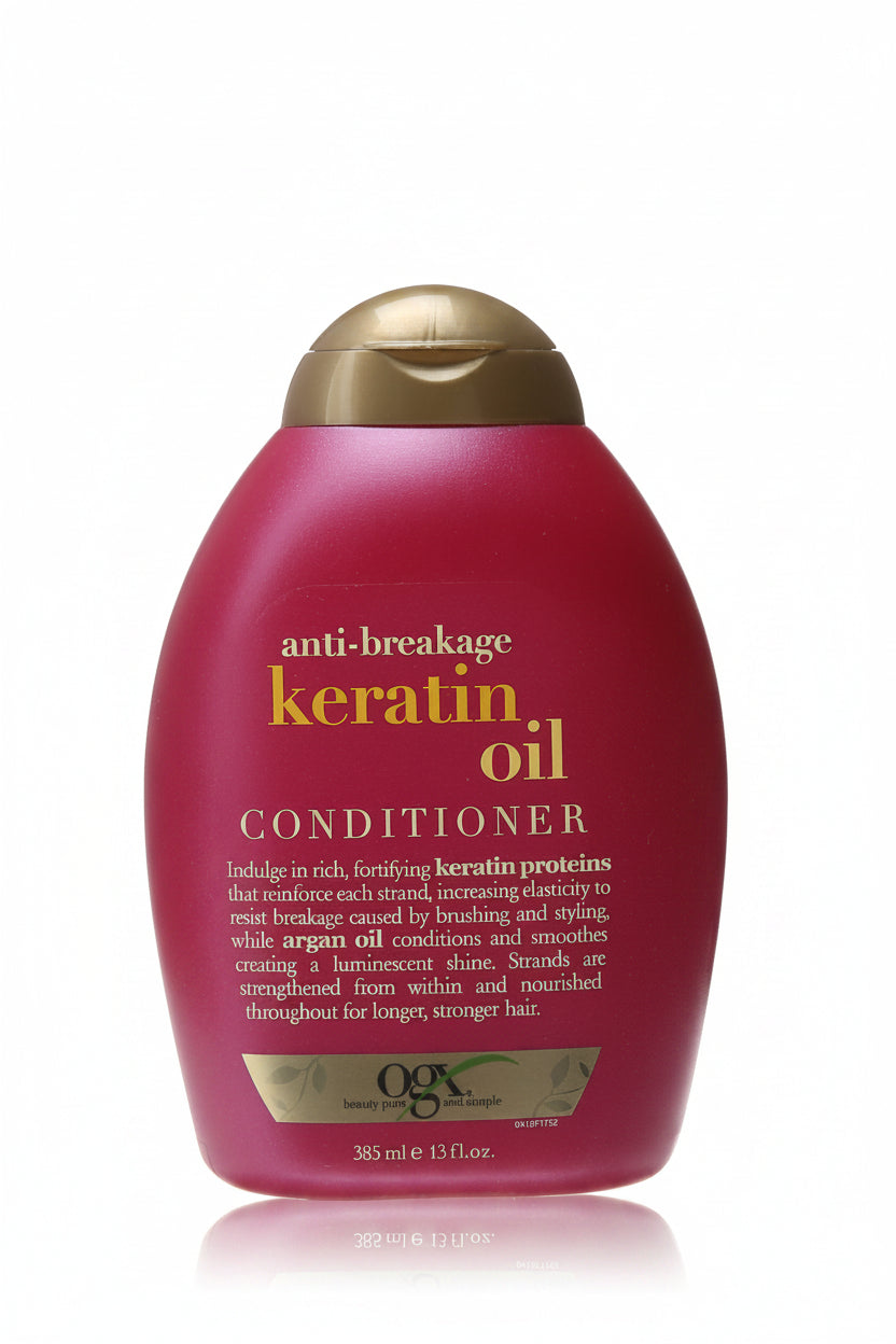 Red conditioner bottle with gold cap on a white background